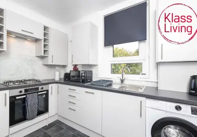 a white kitchen with a sink and a dishwasher at Sanderson Upper by Klass Living Uddingston in Uddingston