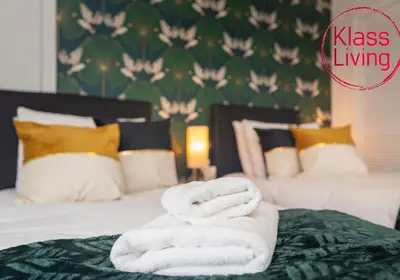 a bedroom with two beds with towels on the bed at Sanderson Upper by Klass Living Uddingston in Uddingston