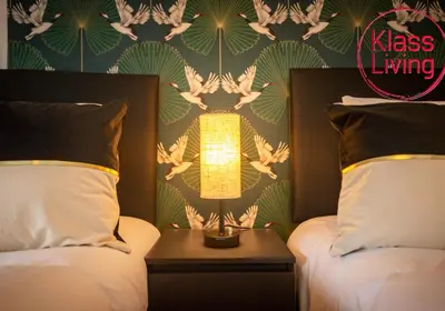 a bedroom with two beds and a lamp between them at Sanderson Upper by Klass Living Uddingston in Uddingston