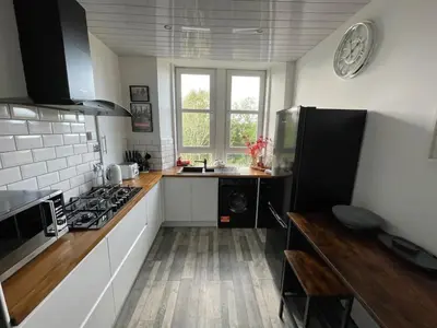 a kitchen with white cabinets and a stove top oven at Isle of Bute Blissful Retreat- Stunning 3 Bed Flat in Rothesay