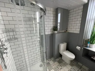 a bathroom with a toilet and a glass shower at Isle of Bute Blissful Retreat- Stunning 3 Bed Flat in Rothesay