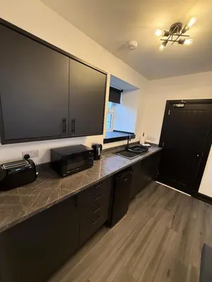 a kitchen with a counter with a large television on it at GlasVenn Cottages in Irvine