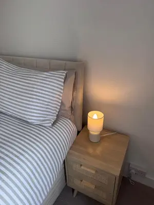 a bed with a night stand with a lamp on it at Helensburgh Central Apartment - Macaulay Letting in Helensburgh