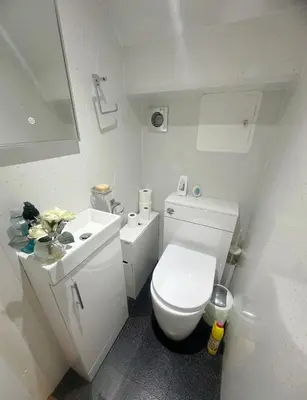 a white bathroom with a toilet and a sink at Galaxy Glasgow 67 in Cardonald