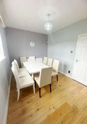 a dining room with a white table and white chairs at Galaxy Glasgow 67 in Cardonald