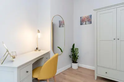a white desk with a yellow chair and a mirror at Lovely Haymarket Apartment - Central Edinburgh in Edinburgh