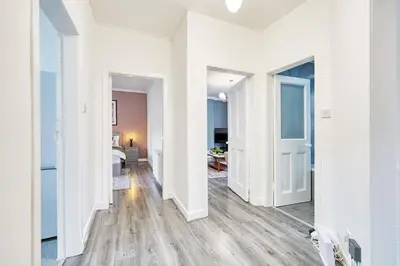 a white hallway with white walls and wooden floors at 2BR Shawlands Free Parking Great Location in Glasgow