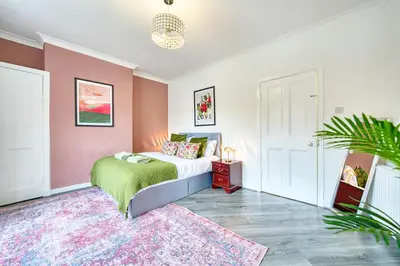 a bedroom with a bed and a pink wall at 2BR Shawlands Free Parking Great Location in Glasgow