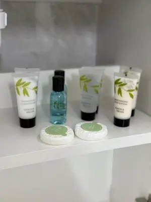 a shelf with four bottles oficating products on it at 2-Bed City Apartment by Glasgow Green in Glasgow