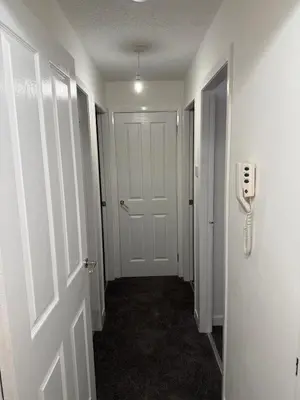 a hallway with a door and a phone on the wall at 2-Bed City Apartment by Glasgow Green in Glasgow