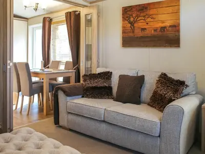 a living room with a couch and a table at Burnside Lodge in Auchterarder