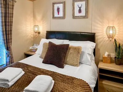 a bedroom with a bed with two pillows on it at Burnside Lodge in Auchterarder