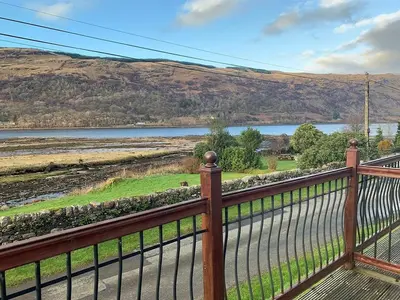 a view of a river from a balcony with a fence at Cairndow Stagecoach Inn in Cairndow