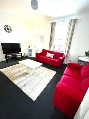 a living room with red furniture and a red couch at Flat 156 at M Rooms in Shotts Station