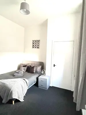 a bedroom with a bed and a white door at Flat 156 at M Rooms in Shotts Station