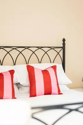 a bed with red and white pillows on it at Birchgate Bothy - Spacious 4 Bedroom Home in Dunoon in Dunoon
