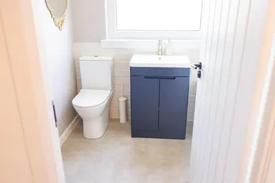 a bathroom with a toilet and a sink and a window at Birchgate Bothy - Spacious 4 Bedroom Home in Dunoon in Dunoon
