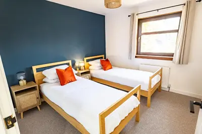 a bedroom with two beds and a window at Birchgate Bothy - Spacious 4 Bedroom Home in Dunoon in Dunoon