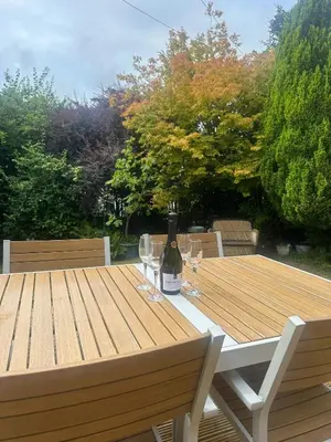 a bottle of wine sitting on a table with wine glasses at Birchgate Bothy - Spacious 4 Bedroom Home in Dunoon in Dunoon