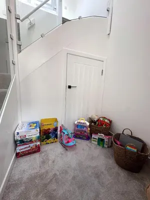 a room with a white door and some books and baskets at Kaimes Kip Stylish Edinburgh Five Bedroom Home in Edinburgh