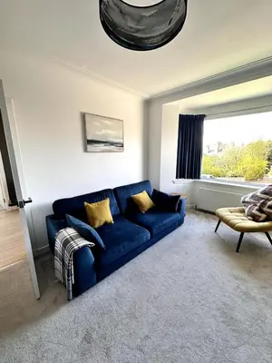 a living room with a blue couch and a window at Kaimes Kip Stylish Edinburgh Five Bedroom Home in Edinburgh
