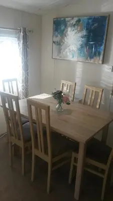 a dining room table with chairs and a wooden table with flowers at Jasper Lodge in Beautiful Glendevon Country Park Perthshire Scotland in Glendevon