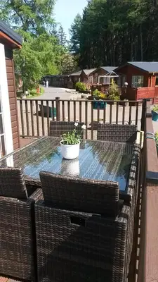 a patio table with chairs and a potted plant on it at Jasper Lodge in Beautiful Glendevon Country Park Perthshire Scotland in Glendevon