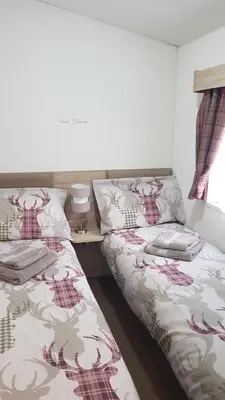 two beds sitting next to each other in a bedroom at Jasper Lodge in Beautiful Glendevon Country Park Perthshire Scotland in Glendevon
