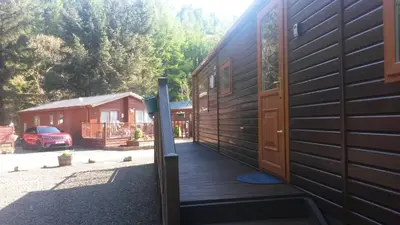 a house with a wooden porch and a door at Jasper Lodge in Beautiful Glendevon Country Park Perthshire Scotland in Glendevon