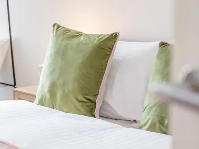 a bed with two green pillows on top of it at Pass the Keys Stay in Glasgow South in Glasgow