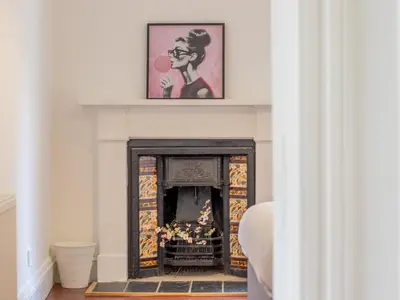 a fireplace in a living room with a painting above it at Pass the Keys Victoria Road Queens Park View in Glasgow