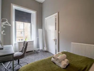 a bedroom with a bed and a desk and a window at Pass the Keys West End Wonder in Glasgow