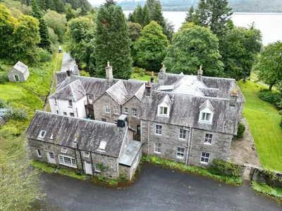 an aerial view of an old house with a driveway at Birch Tree Cottage in Killichonan