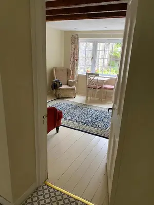 an open door to a living room with a chair at Birch Tree Cottage in Killichonan