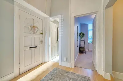 a hallway with a white door and a rug at 3-Bed Flat Free Parking 10 Mins to City Centre in Glasgow