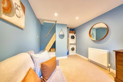 a bedroom with blue walls and a staircase and a mirror at 3-Bed Flat Free Parking 10 Mins to City Centre in Glasgow