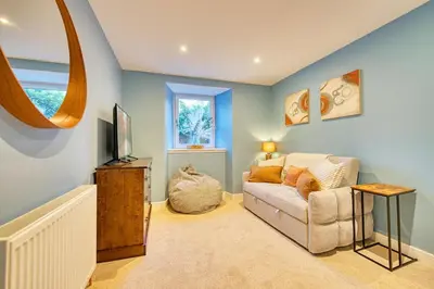 a living room with a couch and a television at 3-Bed Flat Free Parking 10 Mins to City Centre in Glasgow