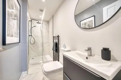 a white bathroom with a sink and a mirror at 3-Bed Flat Free Parking 10 Mins to City Centre in Glasgow