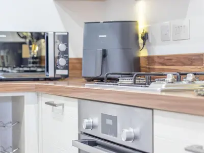 a kitchen with a stove and a microwave at Pass the Keys Next to Braehead - Free Parking in Renfrew