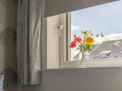 a vase of flowers sitting on a window sill at Pass the Keys Next to Braehead - Free Parking in Renfrew