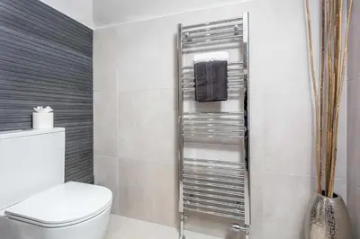 a bathroom with a toilet and a towel rack at No36 South Beach - Donnini Apartments in Troon