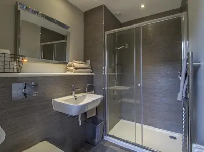 a bathroom with a sink and a glass shower at Haymarket Apartments in Edinburgh