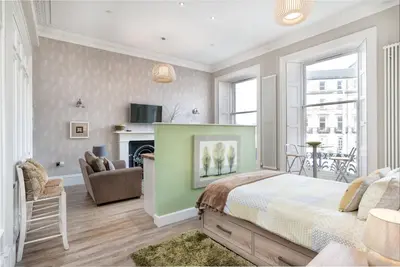 a bedroom with a bed and a living room at Haymarket Apartments in Edinburgh