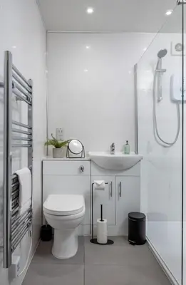 a white bathroom with a toilet and a sink at Ochill View Apartment by Stirling Train Station in Stirling