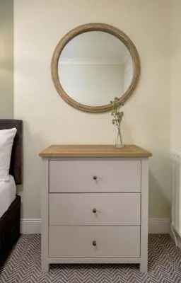 a white dresser with a mirror on a wall at Central Cathedral Apartment in Dunblane