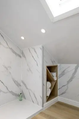 a bathroom with white marble walls and white towels at Historic Trackside Retreat, Charming Getaway in Stirling