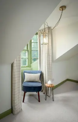a blue chair in a room with a window at Historic Trackside Retreat, Charming Getaway in Stirling
