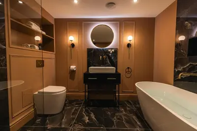 a bathroom with a tub and a sink and a mirror at Luxury Georgian Aparthotel by Hauss Ayr - 5mins to Beach, Town Centre! in Ayr