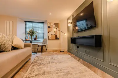a living room with a couch and a flat screen tv at Luxury Georgian Aparthotel by Hauss Ayr - 5mins to Beach, Town Centre! in Ayr