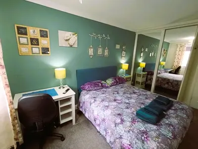 a bedroom with a bed and a desk and a mirror at Double room in riverside apartment - B in Glasgow
